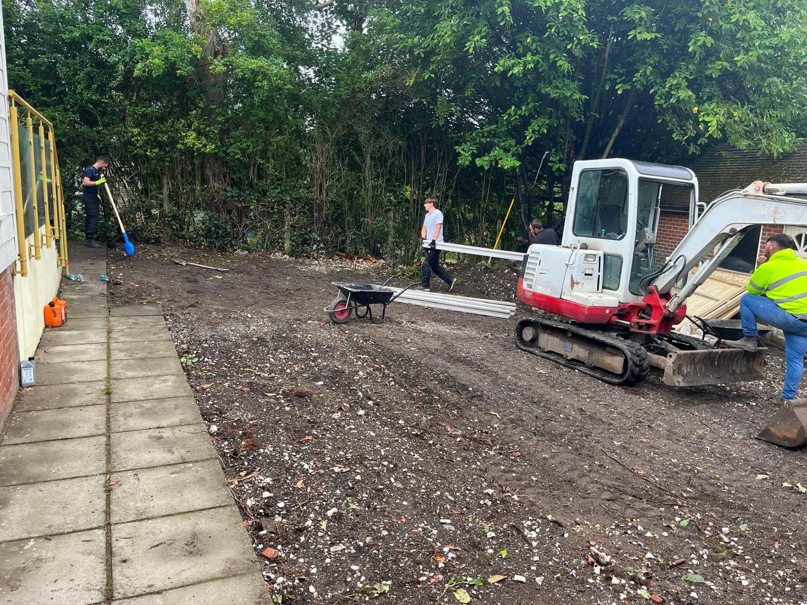 Artificial grass being rolled out and trimmed to the boundary