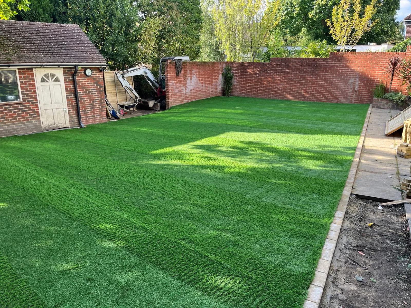 The new lawn laid taut and pinned along the edges