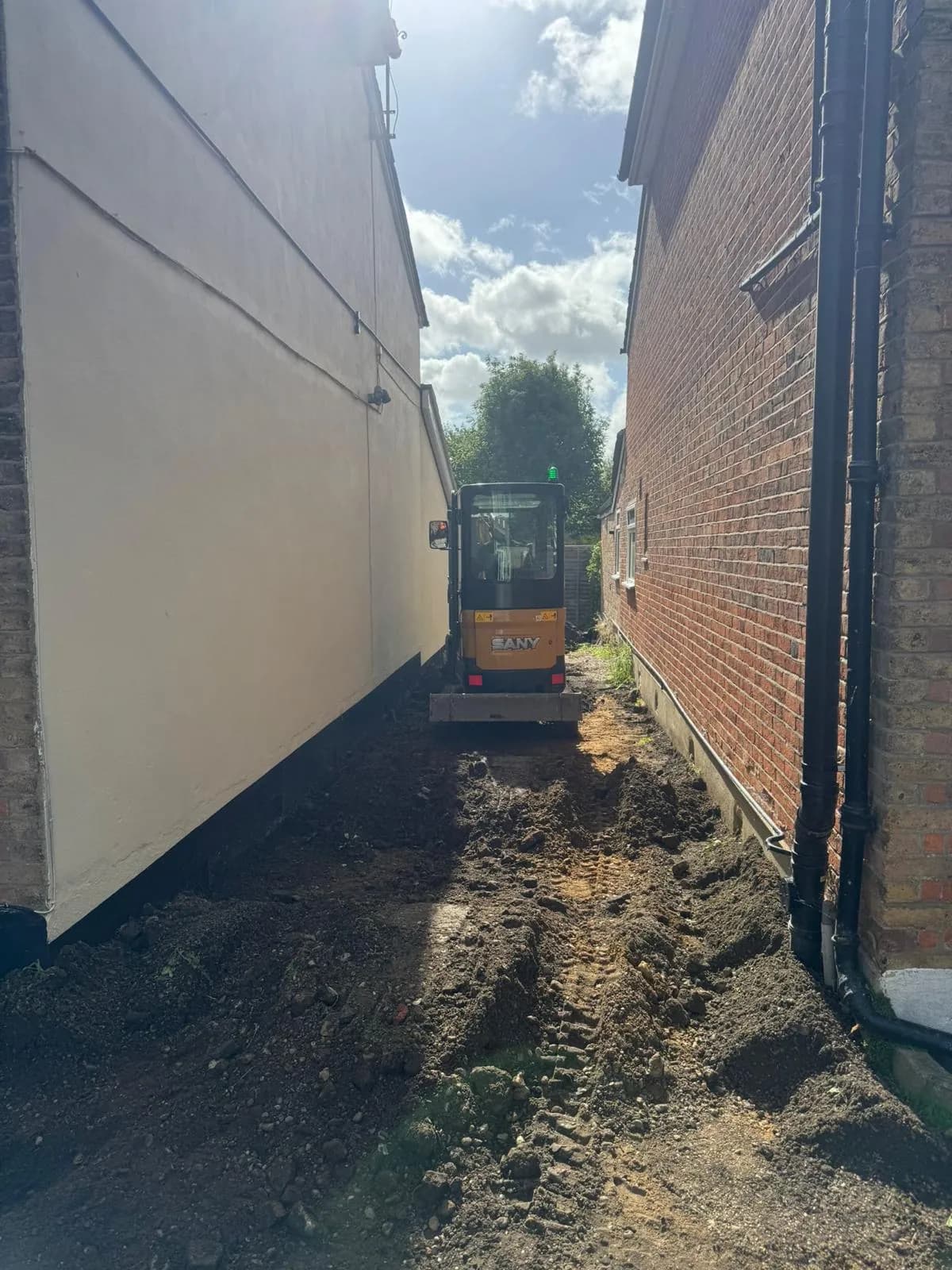 The worn gravel and dirt side access before the works