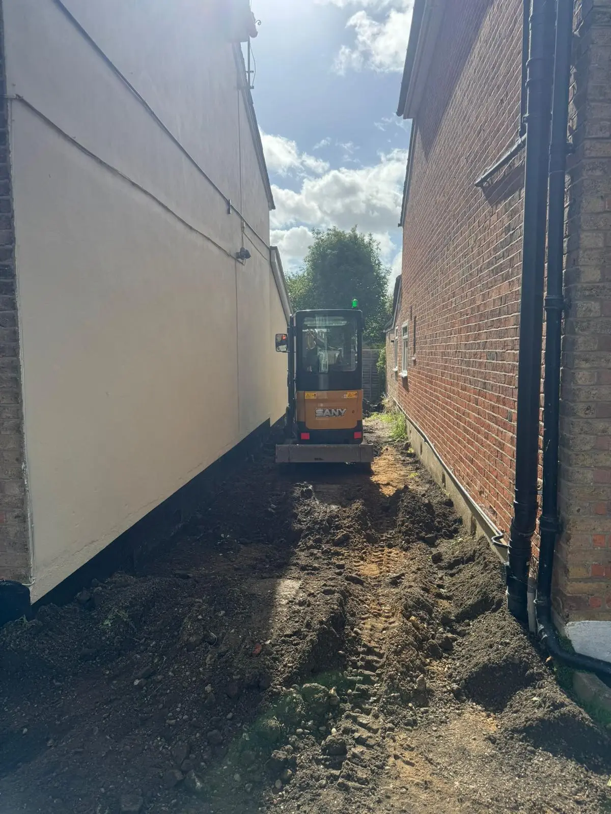 Mini-digger excavating the side access at the start of the works