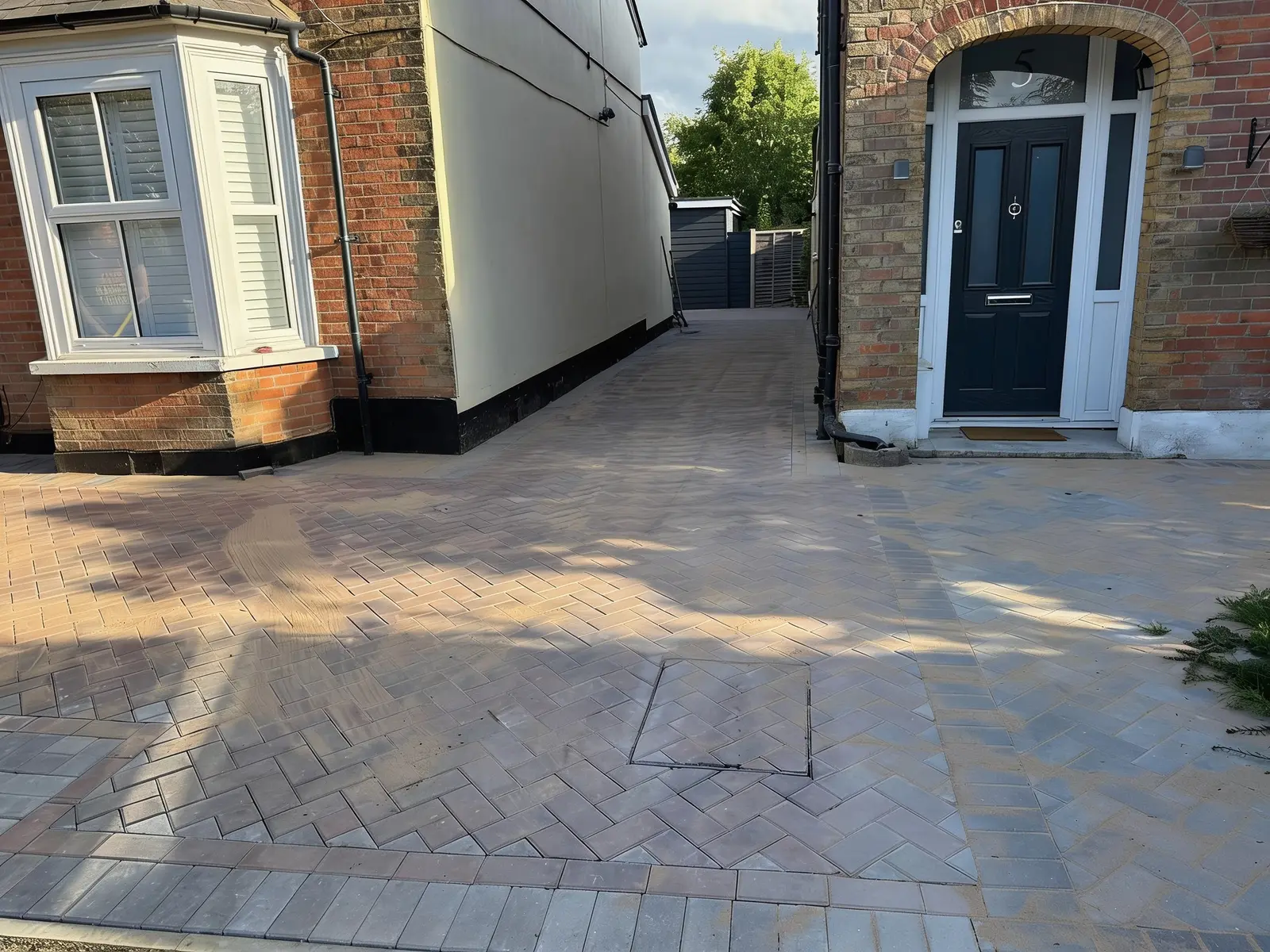 Finished brindle herringbone forecourt with a charcoal soldier-course border