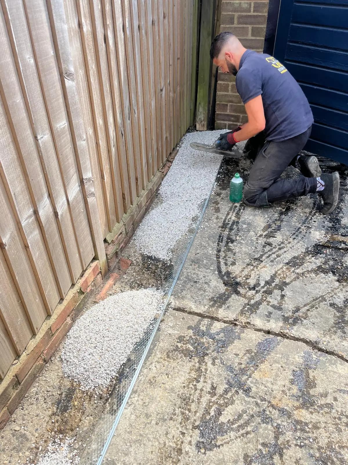 Trowelling the silver-grey resin-bound surface out by hand