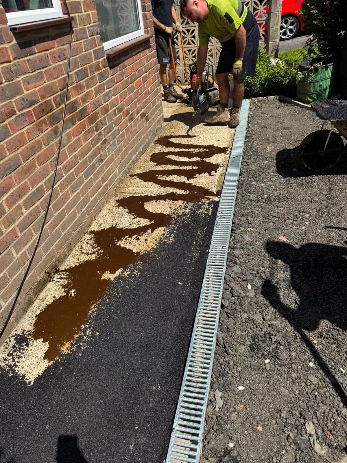 Timber edging and a drainage channel set along the drive