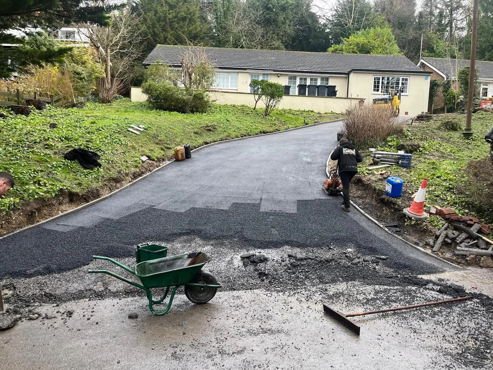 Laying and raking out the fresh tarmac up the sweep of the drive