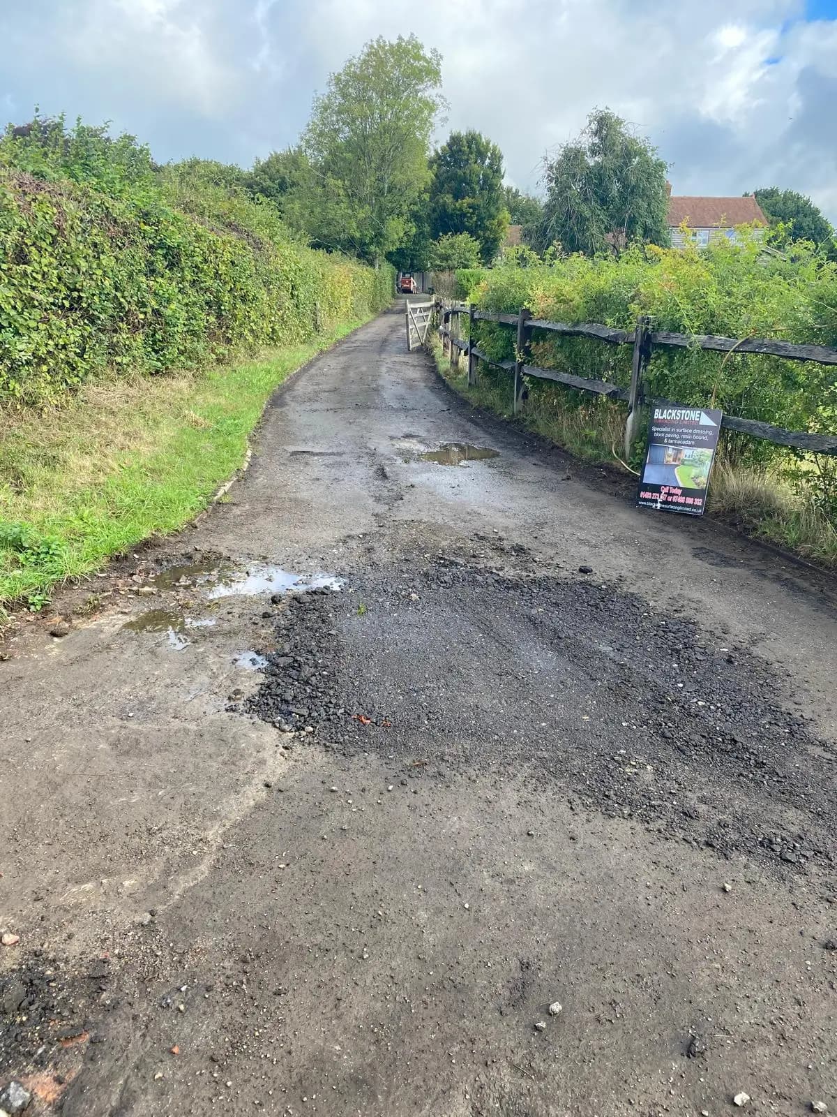 Broken-up, potholed rural lane before resurfacing