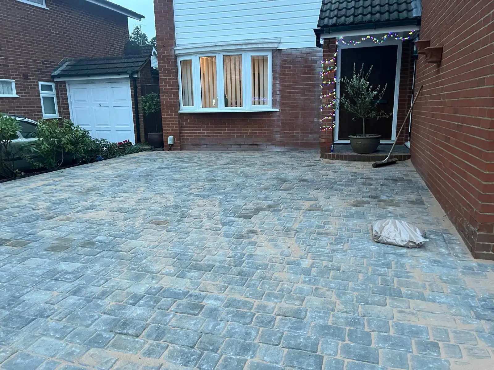 Finished grey tumbled block paving driveway in front of a house in Farnborough