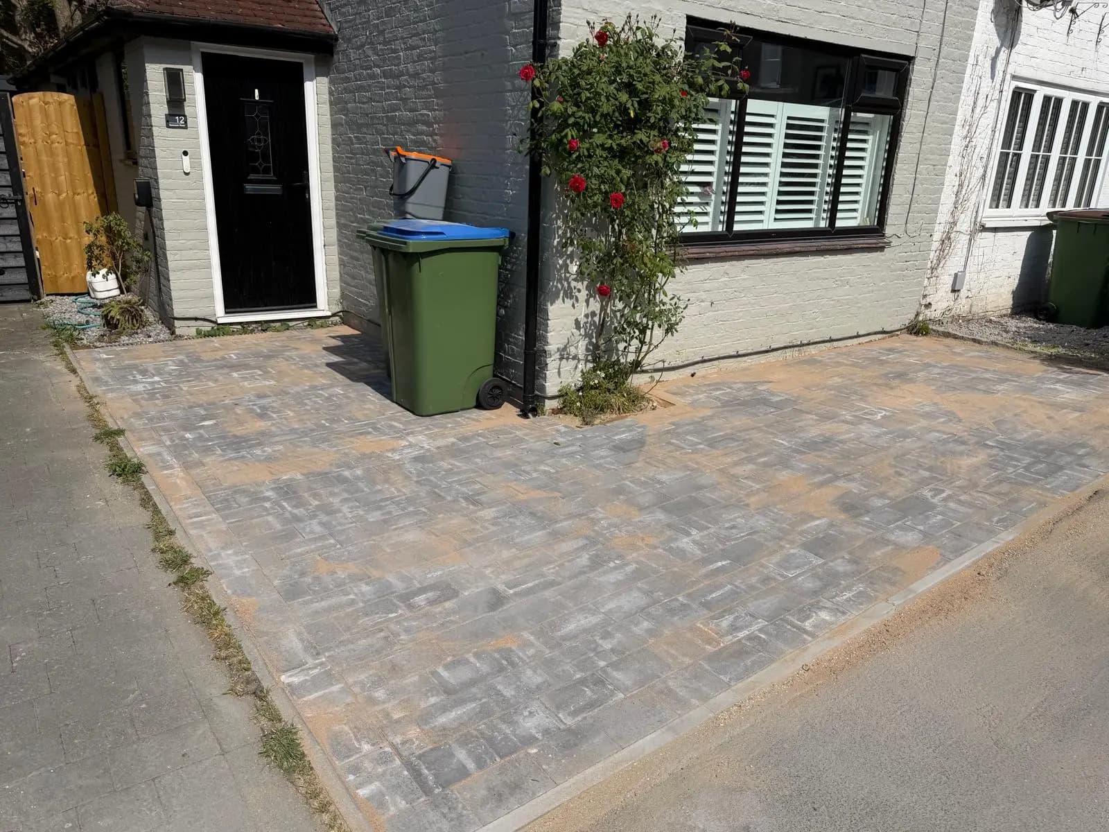 Finished grey block paving driveway at a painted-brick cottage in Horsham