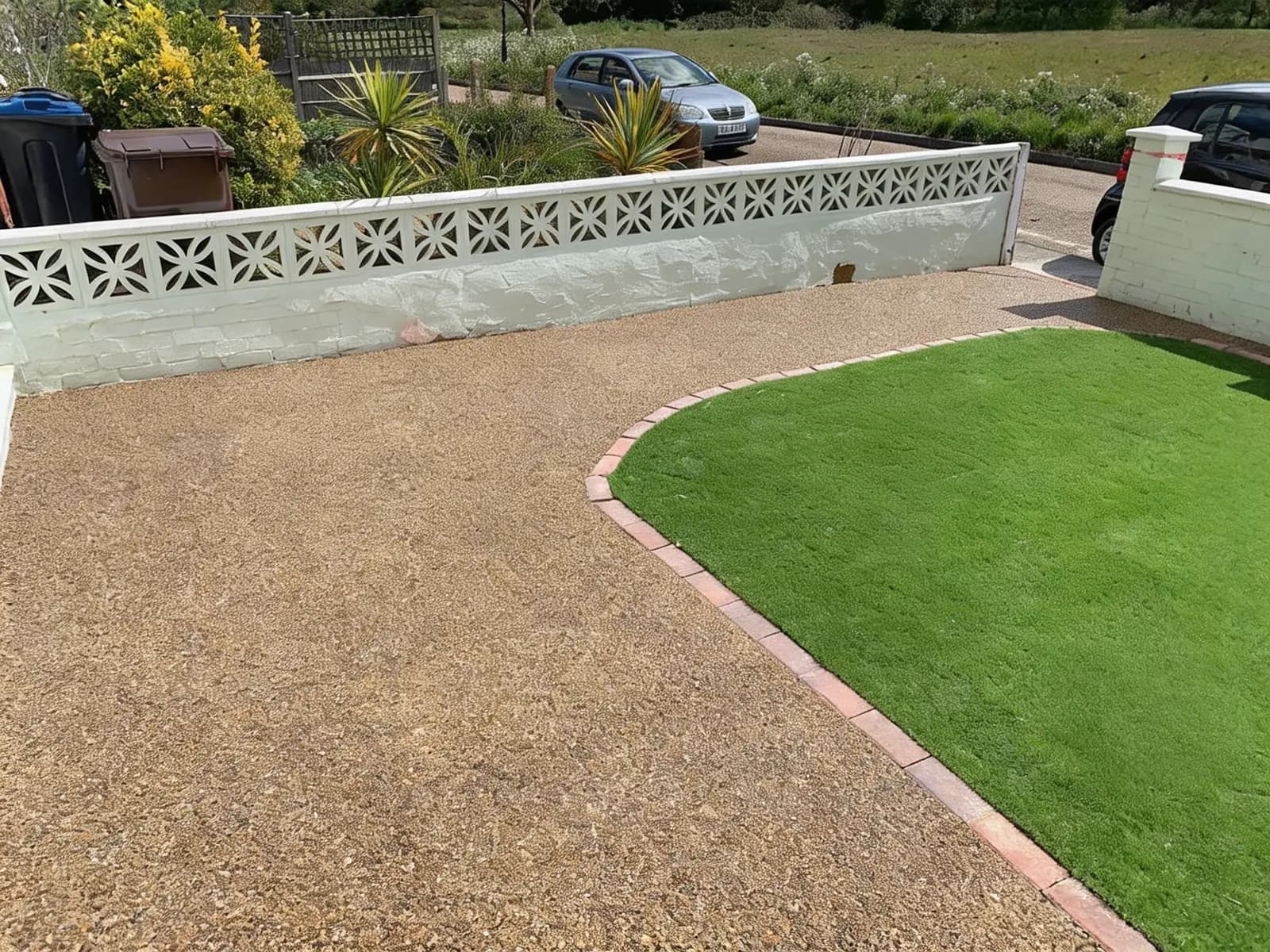 Finished golden resin-bound driveway with a curved brick-edged artificial lawn in Croydon