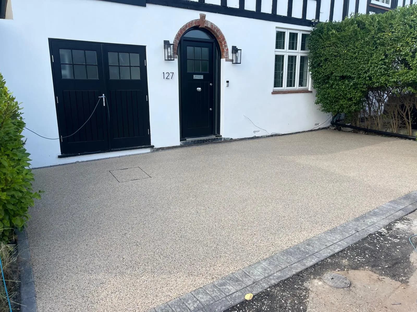 Finished golden resin-bound driveway with a charcoal block border at a period house in Cobham