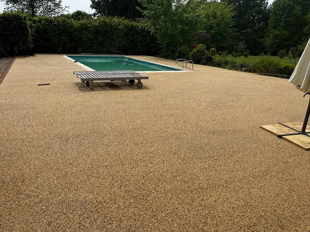 Finished golden resin-bound surround to a garden swimming pool