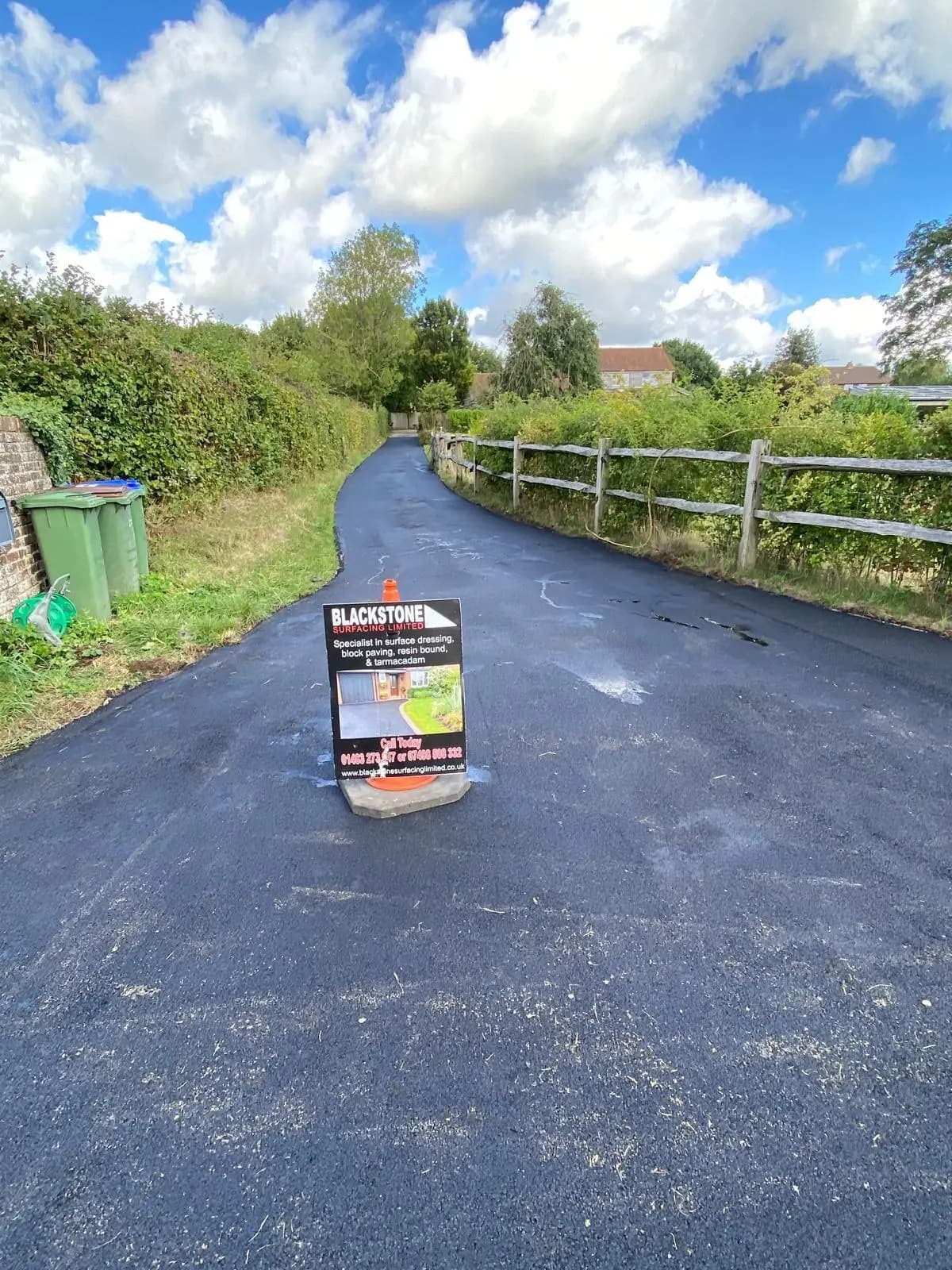 Finished tarmac lane through open countryside in Cowfold, West Sussex